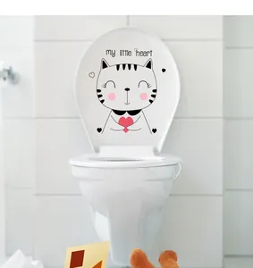 Close-up of a cute cartoon cat with a pink heart sticker applied on a white toilet lid
