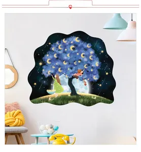 Détail de l'autocollant mural 3D avec arbre bleu onirique, lunes et étoiles jaunes