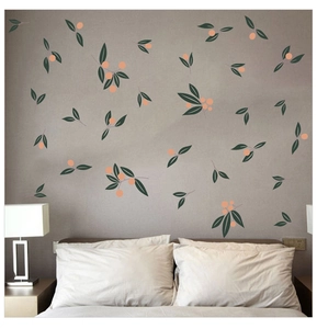 Detail of green leaf and orange berry wall decals applied to a gray bedroom wall