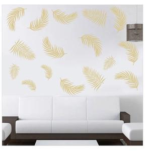 Detail of golden palm leaf wall stickers applied on a white bedroom sofa background