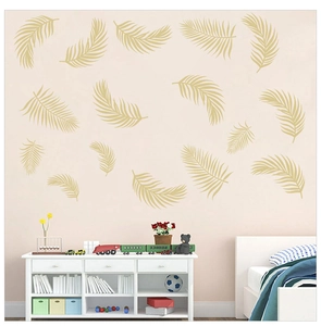 Detail of champagne gold palm leaf wall stickers on a modern soft pink bedroom wall