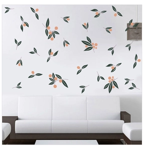 Detailed view of hand-painted olive branch wall stickers above a white modern sofa