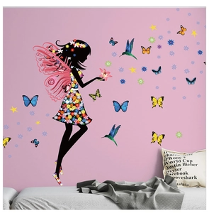 Détail des stickers muraux fée colorée et papillons sur un mur rose de chambre
