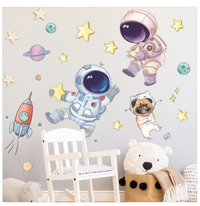 Detail of cartoon astronaut, rocket and star wall stickers in a cozy nursery room setting