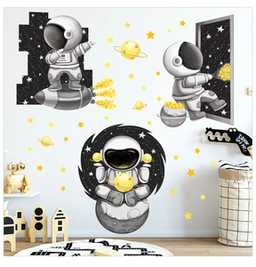 Detail view of cartoon astronaut wall stickers applied on a clean white nursery room wall