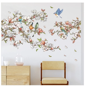 Detail of artistic magnolia flower wall stickers with colorful birds on a white bedroom wall
