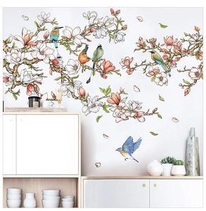 Detail of floral wall sticker with magnolia blossoms and colorful birds on white wall