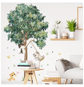 Détail d'un sticker mural montrant des chats mignons jouant autour d'un grand arbre vert