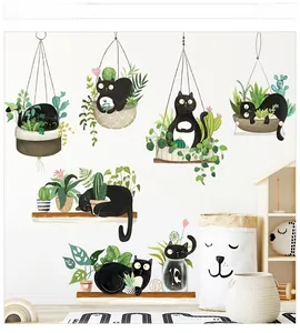 Detail of cute black cat wall stickers with green hanging plants for home decoration