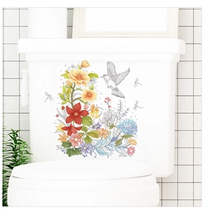 Détail d'autocollant aquarelle de fleurs et oiseaux sur un réservoir de WC blanc
