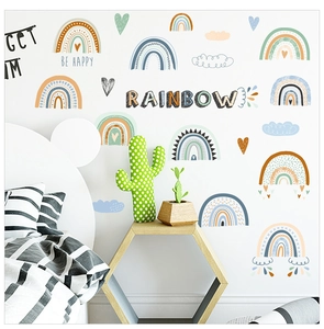 Detail view of colorful DIY boho rainbow wall stickers with clouds in a nursery bedroom