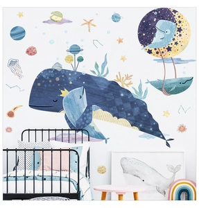 Detail of whale and planet wall decals in a cozy children room with soft colors