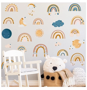Detail view of boho rainbow and cloud wall decals in a cozy nursery with a white rocking chair