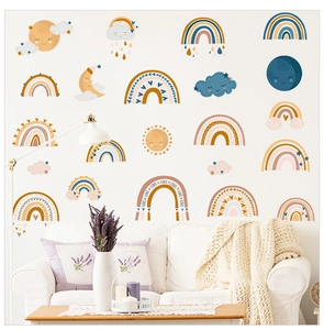 Detail of boho nursery wall decals with rainbows, sun and moon on white wall above sofa