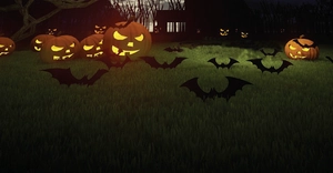 Outdoor Halloween decor featuring black bat silhouettes and glowing pumpkin lanterns on grass