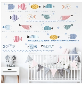 Detailed view of colorful cartoon fish wall stickers in a cozy white nursery room