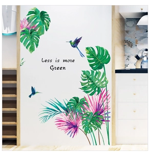 Detail of tropical monstera leaf wall stickers with hummingbirds and green text