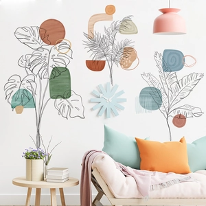 Boho botanical wall stickers with monstera leaves and geometric shapes over a sofa