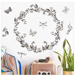 Détail de stickers muraux avec couronne de feuilles et papillons sur un mur de salon blanc