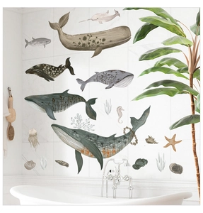 Gros plan d'autocollants muraux baleine aquarelle avec motifs floraux sur carrelage marbre