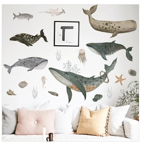 Détail de stickers muraux baleines à l'aquarelle avec motifs floraux sur mur de salon cosy