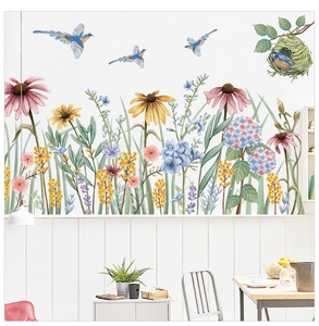 Detailed close-up of floral wall stickers with birds and daisies on a white baseboard
