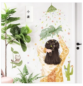 Detail of girl and cat wall decals on a white door with fresh green leaf elements