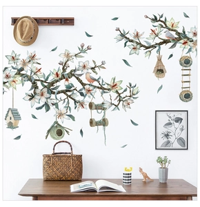 Detail of floral wall decals featuring white blossoms and hanging birdhouses in a home