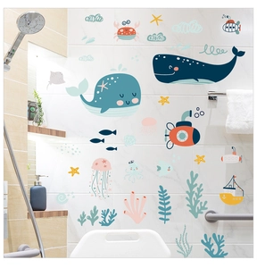 Detail of whale and ocean wall stickers on white bathroom tiles near a shower head