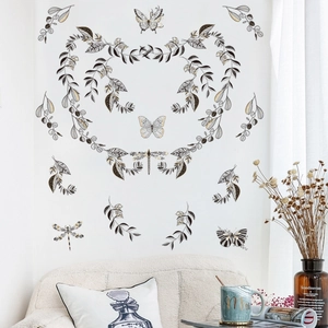 Stickers muraux vintage papillons et feuilles sur un mur blanc avec canapé