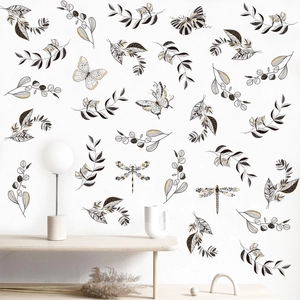 Stickers muraux minimalistes avec feuilles dorées et papillons sur un mur blanc
