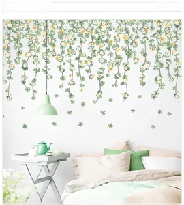 Detail of hanging green vine wall decals with white daisies in a cozy bedroom scene