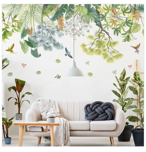 Detail of tropical green leaf wall stickers with birds above a modern sofa