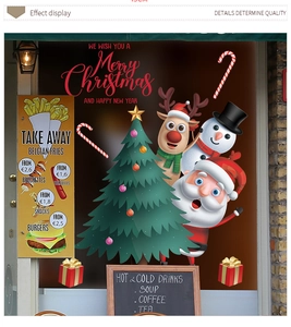 Dettaglio di adesivi natalizi con albero e renna su una vetrina di un negozio