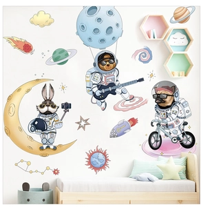 Cartoon space wall stickers featuring astronaut animals and planets over a kid's bed
