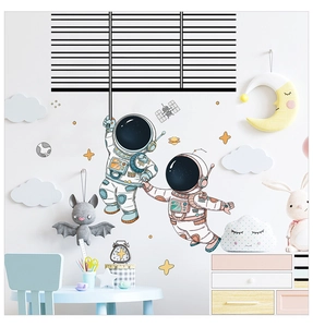 Detail of hand-drawn astronaut wall stickers with planets for a cozy kids' room decor