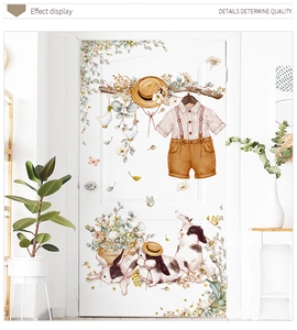 Detail of cute rabbit wall stickers with plants and clothes on a white door