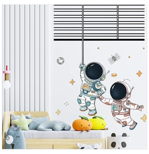 Detail of cartoon astronaut wall decals with planets and stars in a cozy child's bedroom