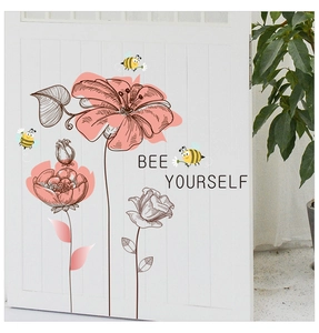 Detail of flower stickers with cartoon bees and Bee Yourself text on white wooden door