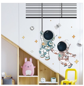 Detailed view of cartoon astronaut wall decals with stars in a cozy child's bedroom