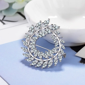 Vue macro d'une broche couronne en argent sertie de zircons et cristaux de taille marquise