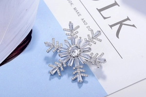 Détail macro de la broche flocon de neige argentée avec zircons coupes baguette et rond