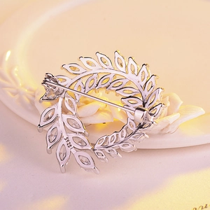Détail d'une broche en forme de feuille avec zircons et poinçon en argent S925