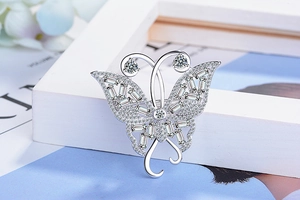 Vue détaillée d'une broche papillon argentée avec zircons blancs et diamants de taille baguette