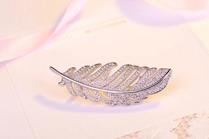 Close-up of feather brooch with silver plating and pavé-set sparkling zircons