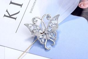 Détail macro d'une broche papillon en argent avec zircons et épingle dorée longue