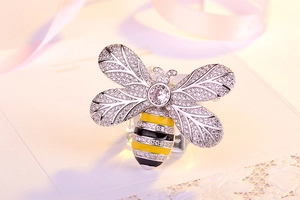 Macro shot of bee brooch with inlaid zircon wings and yellow enamel abdomen details