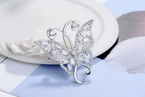 Gros plan d'une broche papillon élégante sertie de zircons blancs sur un support argenté