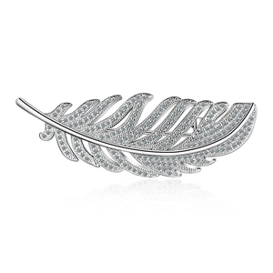 Elegant silver feather brooch with sparkling zircons and a polished finish on white background