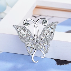 Élégante broche nœud en argent avec zircons sertis sur un cadre en bois blanc